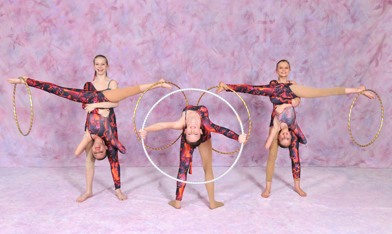 Five dancers posing with hula hoops