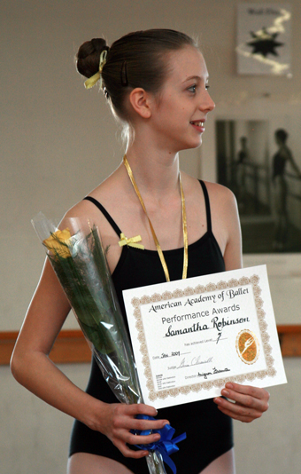 Female ballet student holding an American Academy of Ballet certificate